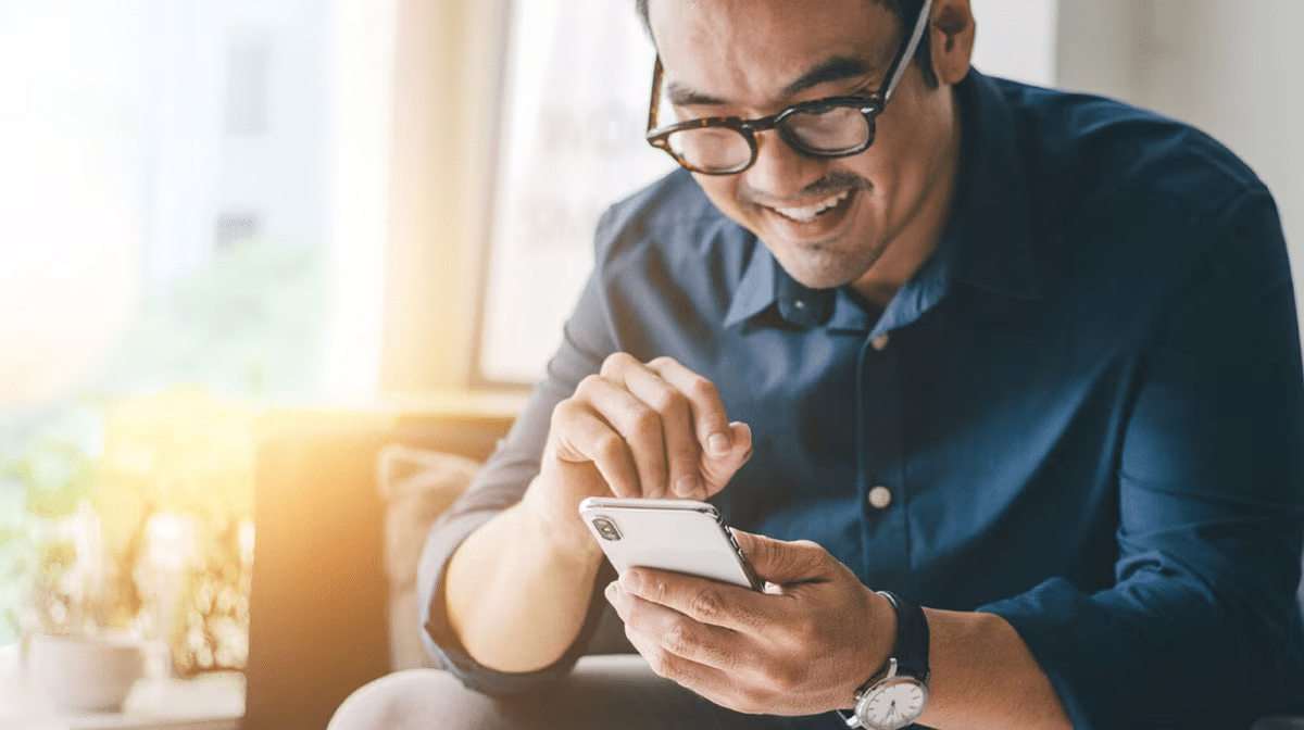Person sitting on a sofa using a smart phone.
