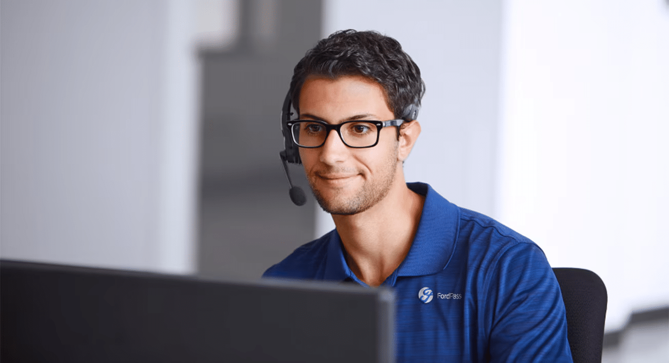 Person at a call centre wearing a headset and looking at a monitor.