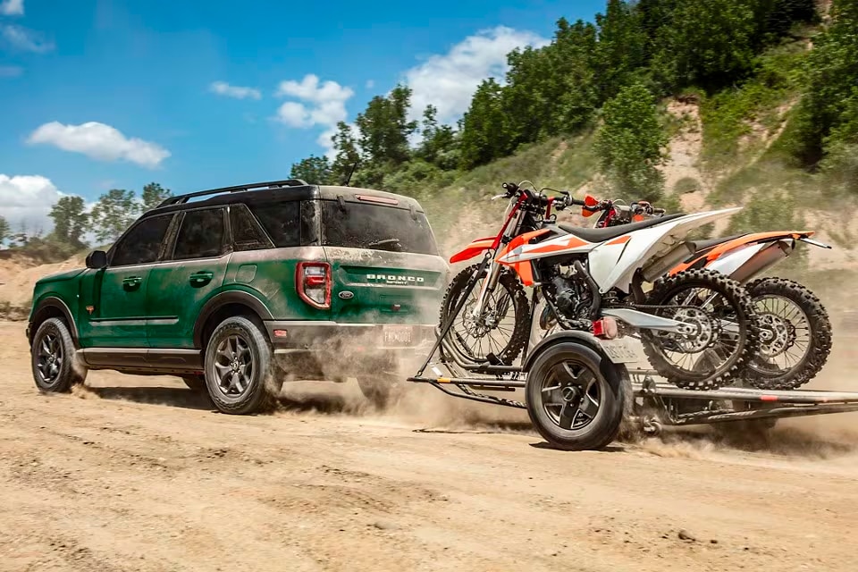 Ford Bronco Sport with attached trailer loaded with dirt bikes.