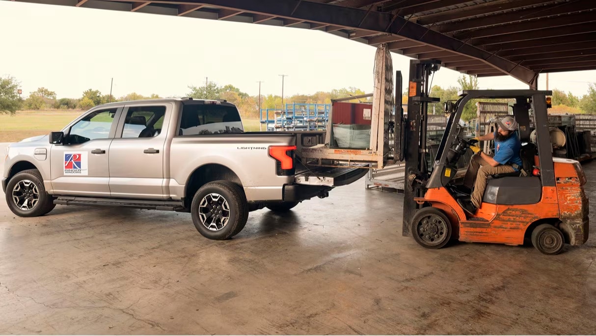 The setting, a lumber yard. On the right, a forklift. To the left, a Ford F150 truck being loaded.